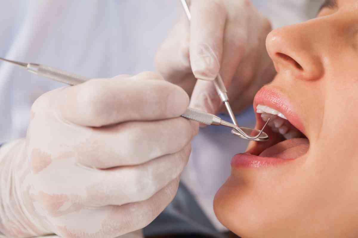 Dentista che esamina i denti di una paziente