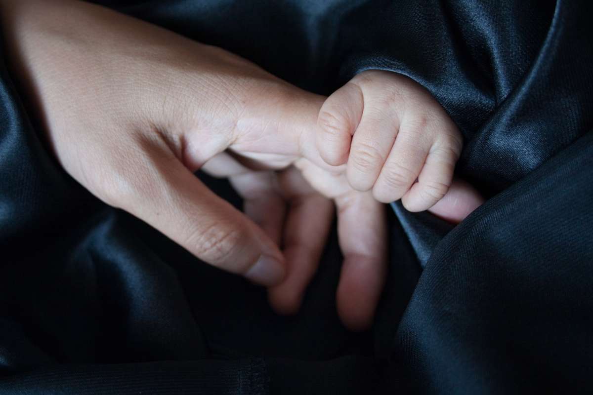 La mano di una madre con quella del figlio